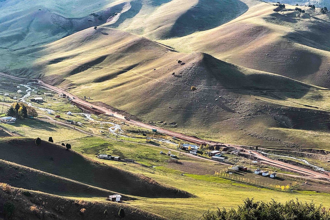 A single road winds among hills in Tien Shan Mountains