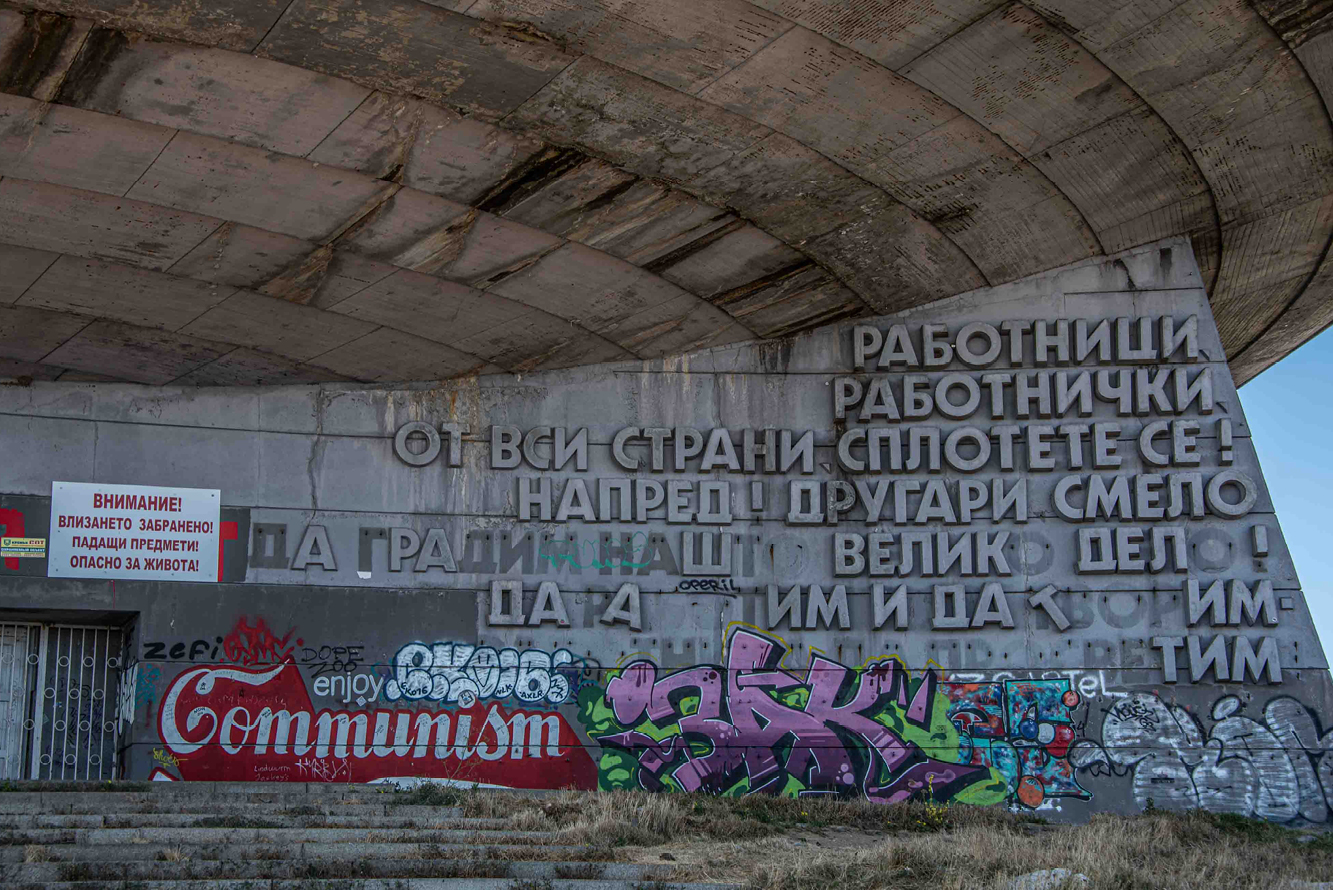 Colorful graffiti serves as a counterpoint to the communist philosophy espoused in the formal quotes