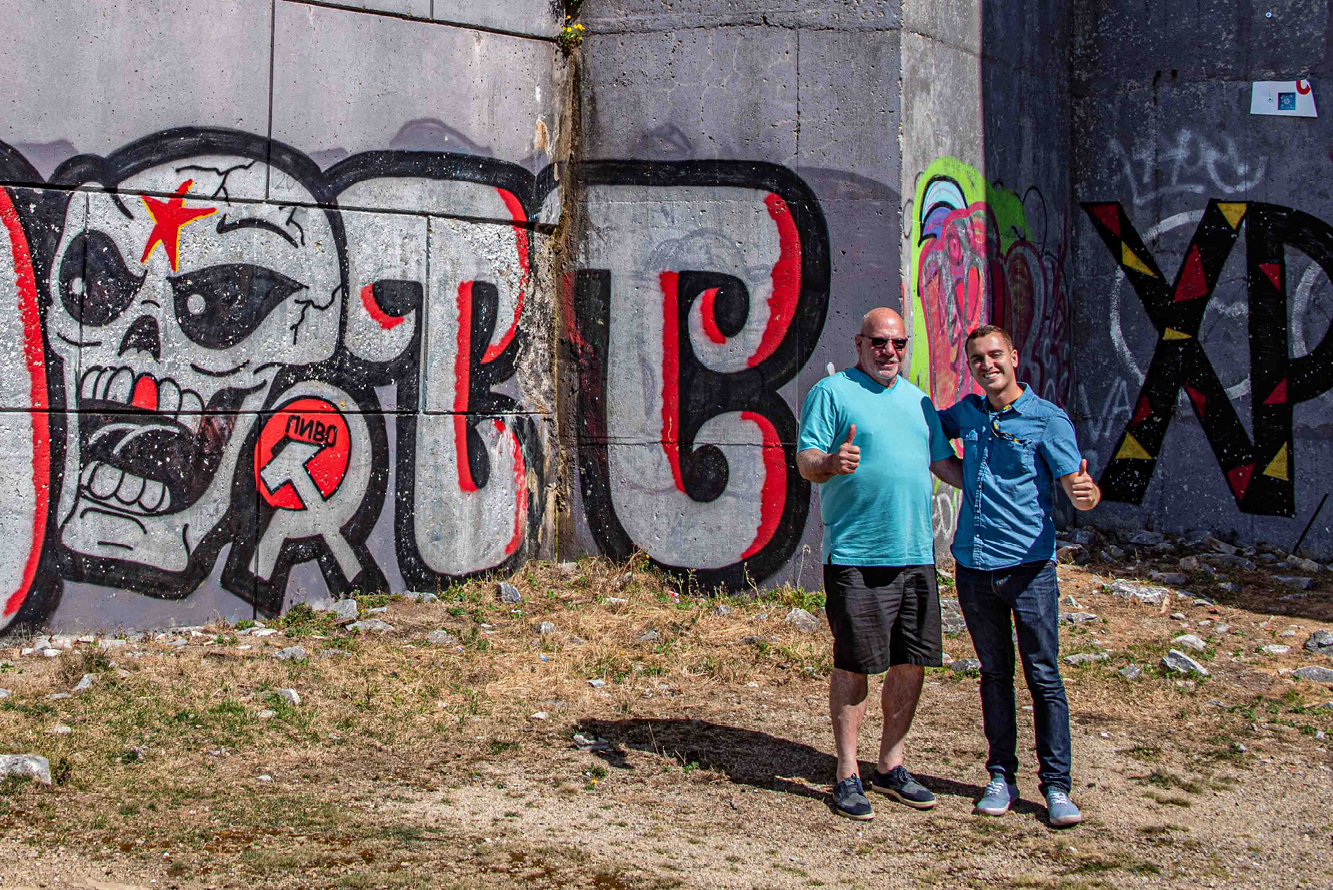 Our guide Volen poses with Rick at the base of the tower near a graffiti skull complete with the red star and Soviet hammer and sickle